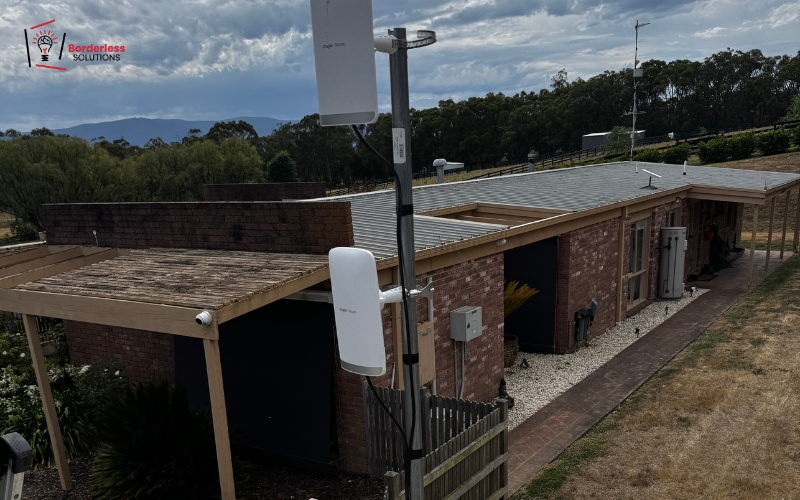 TV antenna mast mounted on residential brick house exterior wall - screen mounting and TV point installation service