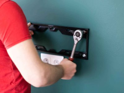 Technician mounting a TV bracket securely on the wall for a clean home entertainment setup in Melbourne. Borderless Solutions provides professional and safe TV wall mounting services throughout Melbourne for residential and commercial clients.