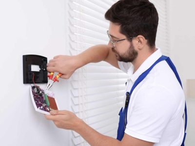 alarm-system-installation-melton Technician wiring and installing a modern alarm system in Melton. Borderless Solutions provides alarm installation, maintenance, and smart integration.