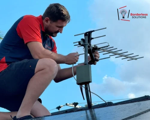 Technician adjusting TV antenna for signal reception - professional aerial installation and repair service