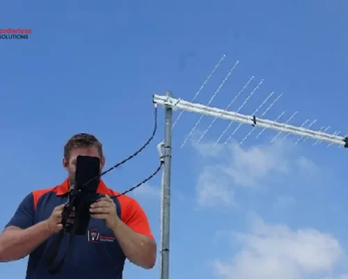 TV antenna signal testing service - technician checking signal strength for optimal reception
