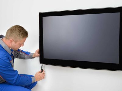 tv-wall-mounting-melton Technician mounting a flat-screen TV on the wall in Melton. Borderless Solutions offers TV wall mounting, antenna installation, CCTV setup, and smart home services.